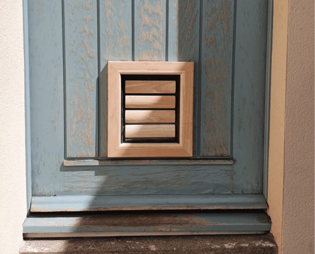 Beautiful wooden front door in Provence in France with a natural wooden cat flap made by Tomsgates